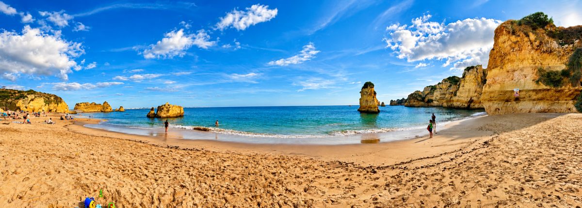 Weiter Sandstrand zwischen Felsen